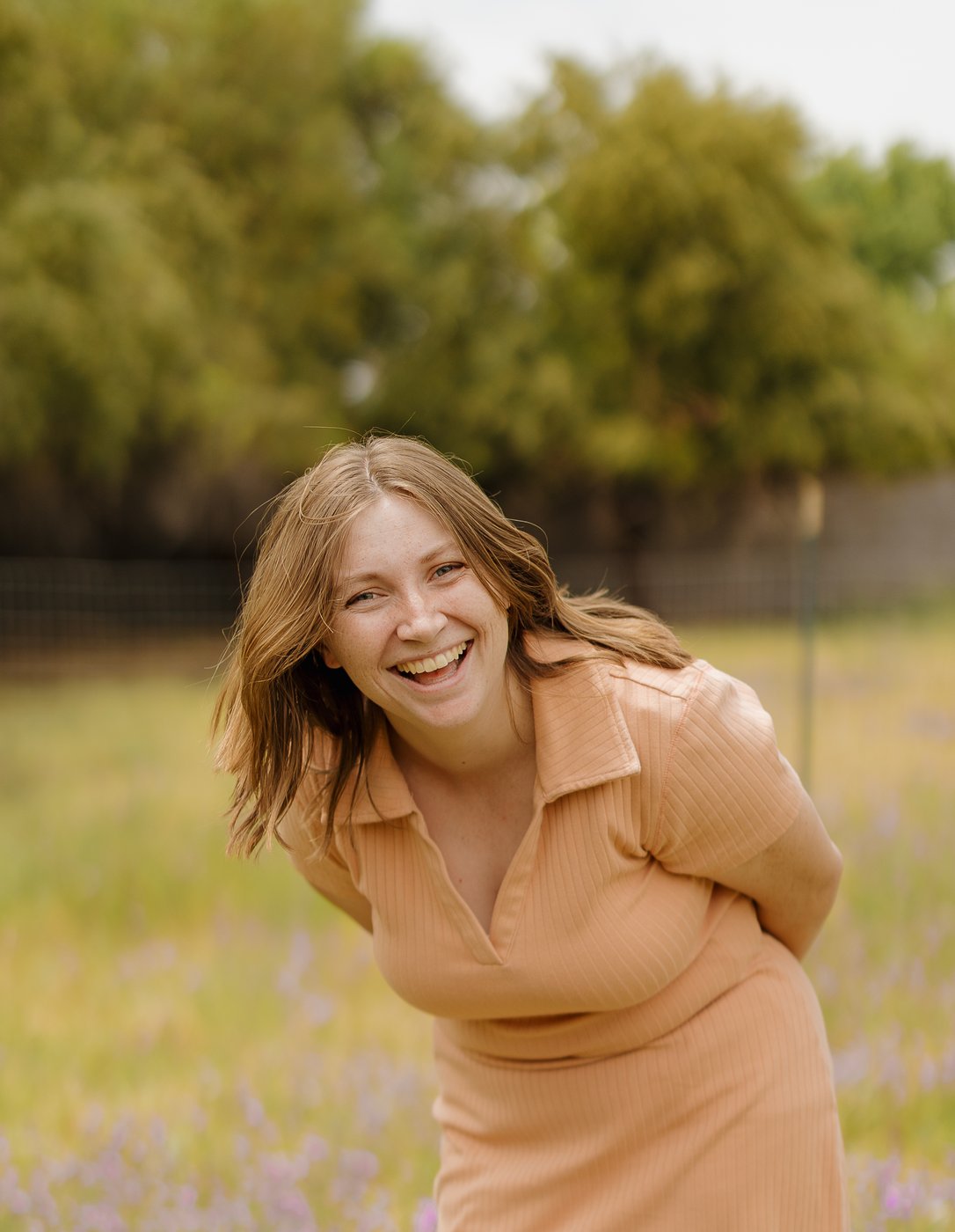 Elise, founder of Simple Sage Spaces, smiling outdoors in a wildflower field